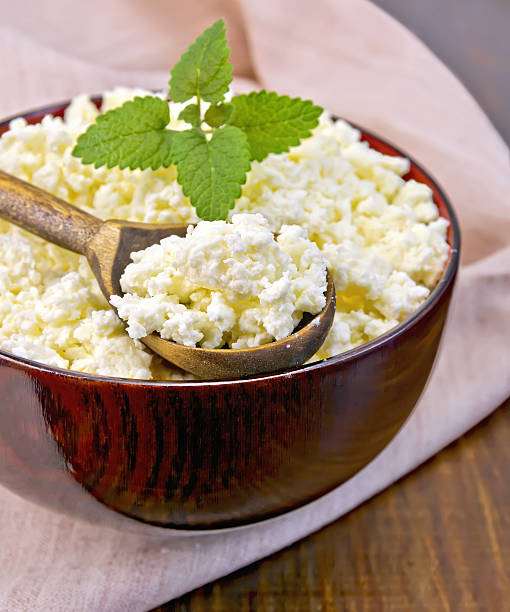 istock Curd in wooden bowl with spoon on board 518458027