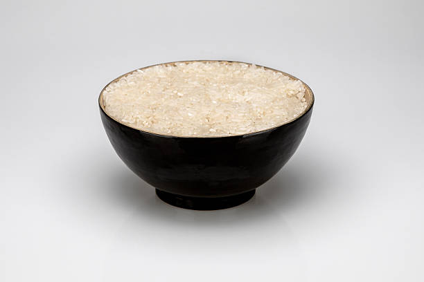 istock Black bowl with rice, isolated on white background 518458583