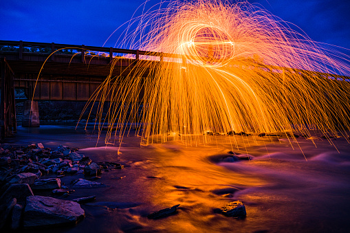 Spinning Sparks with Bridge and Colorado River - Dusk night image with glowing fire and sparks spinning geometry.
