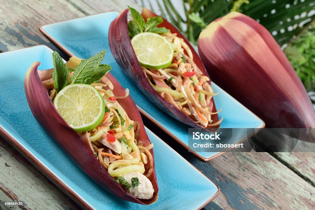 Vietnamese Banana Blossom Salad Traditional Vietnamese banana blossom salad, made with shredded banana flowers, vegetables, mint, chili peppers, and chicken, served in a banana flower petal. Banana Stock Photo