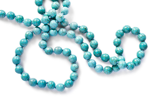 String of turquoise beads isolated over white