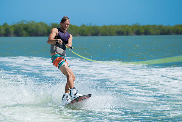 wakeboarder behing una barca - wakeboarding foto e immagini stock