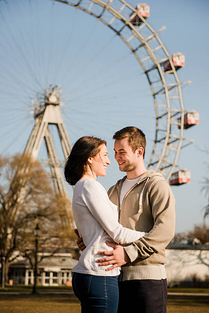 istock Young couple dating in amusement park 518464180