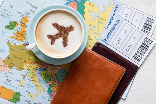 Avión hecho de canela en un capuchino, pasaportes y Mapa de Europa photo