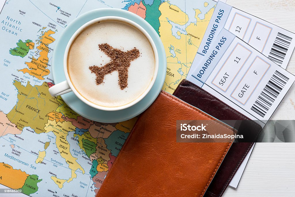 Avión hecho de canela en un capuchino, pasaportes y Mapa de Europa - Foto de stock de Billete de avión libre de derechos