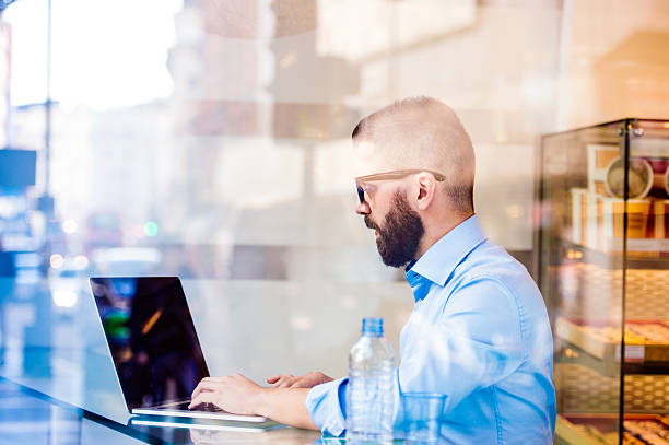 istock Hipster manager in cafe, working on laptop by window 518466354