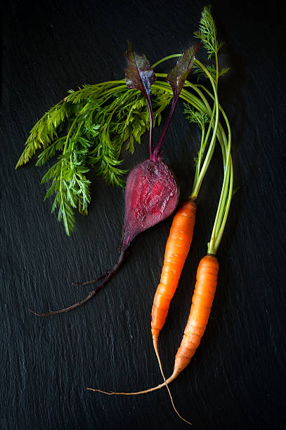 Raw carrots and beets. Background chalk board