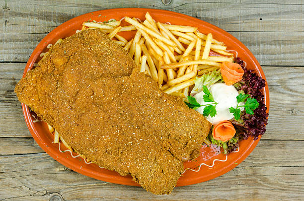 grand wiener schnitzel sur une plaque en argile avec des frites - schnitzel cutlet pork food and drink industry photos et images de collection