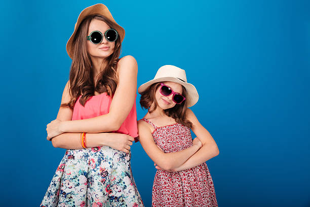 istock Two pretty smiling sisters standing and posing with hands folded 518468094