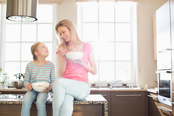 istock Happy mother and daughter having breakfast in kitchen 518468125