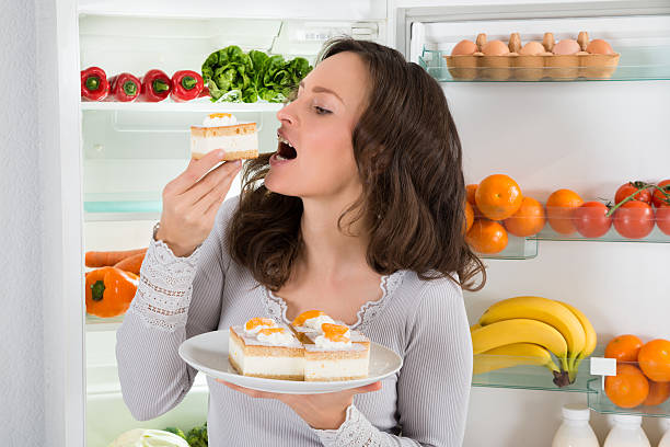 istock Woman Eating Slice Of Cake 518468474