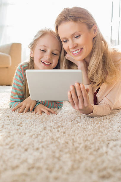 istock Happy mother and daughter using digital tablet 518472571