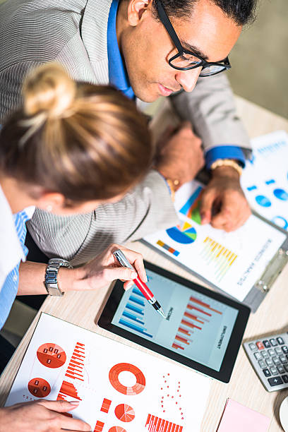 istock Successful young entrepreneurs analyzing stock market data in office 518472706