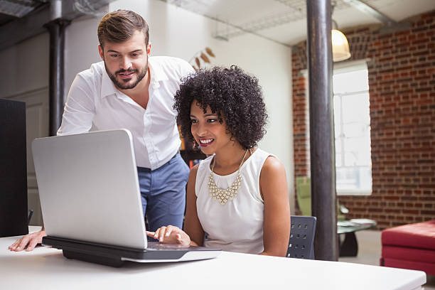 istock Casual business team looking at laptop together 518481561