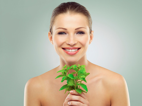 Studio portrait of a beautiful young woman holding sprigs of mint against a green backgroundhttp://azarubaika.com/iStockphoto/2014_05_09_Victoria_Beauty.jpg