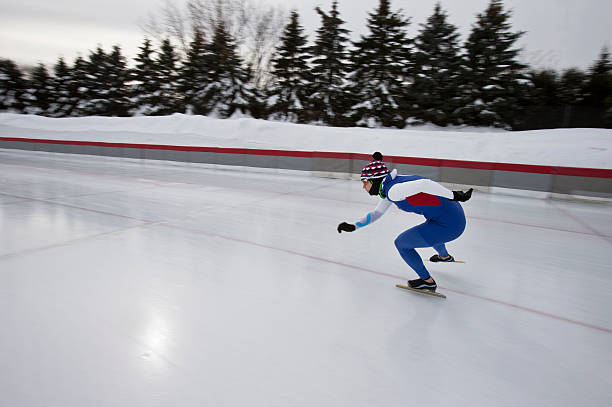 A female athlete speed skating on a cold winter day.