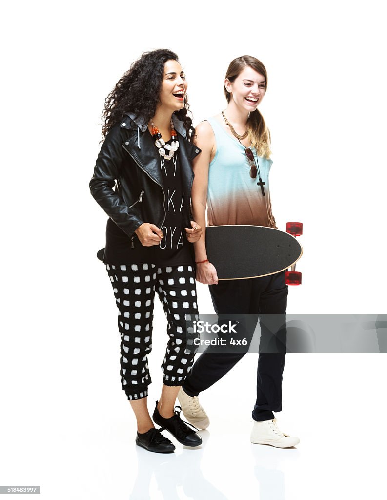 Two cheerful women holding skateboard & walking Two cheerful women holding skateboard & walkinghttp://www.twodozendesign.info/i/1.png 20-29 Years Stock Photo