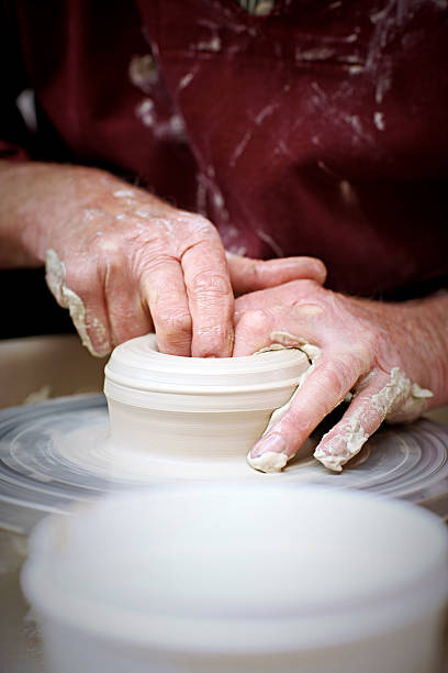 istock Hands of old potter moulding a vase 518484513