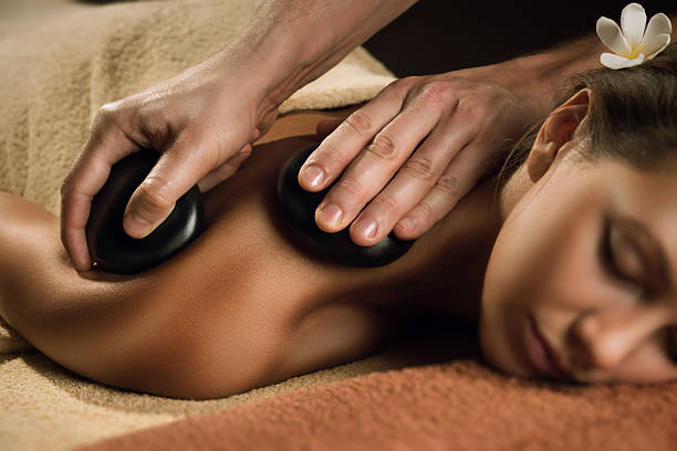 hermosa chica con masaje de piedras. - massage stones fotografías e imágenes de stock