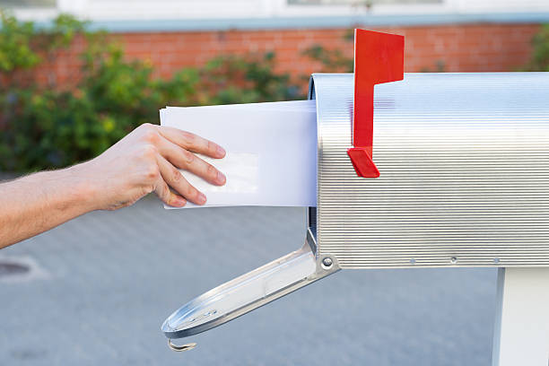 istock Person Removing Letters From Mailbox 518494234