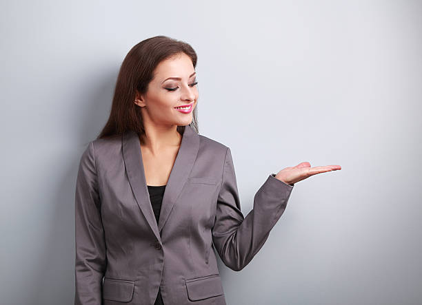 istock Happy business woman holding something empty in hand 518494970