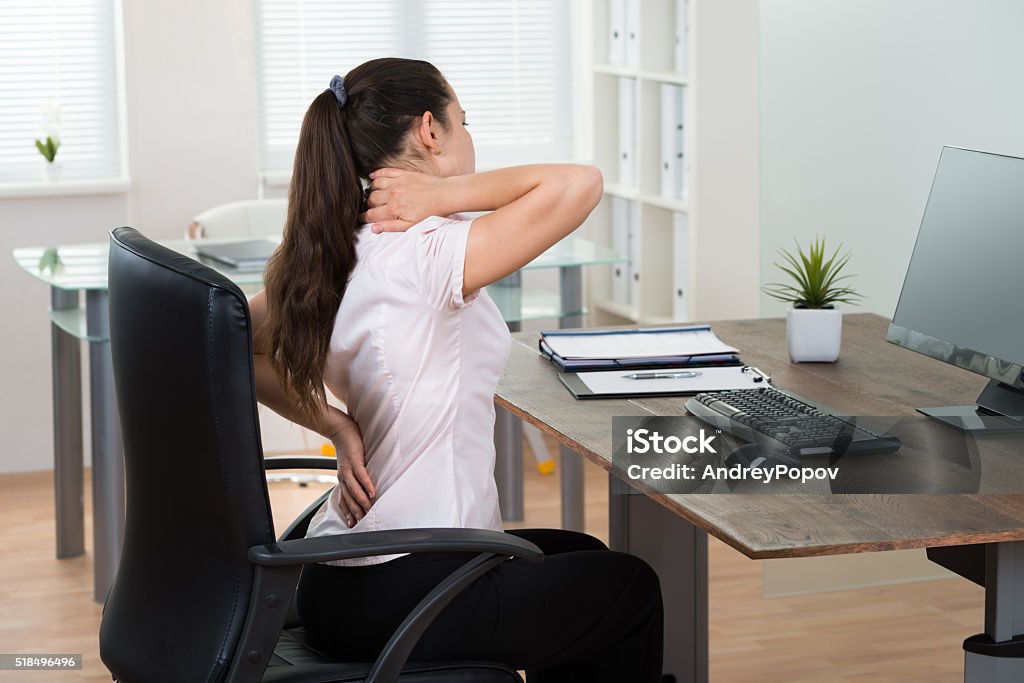 Businesswoman Having Backpain In Office Young Businesswoman Sitting On Chair Having Backpain In Office Backache Stock Photo