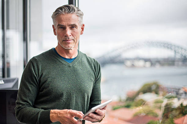 retrato de um homem de negócios com tablet digital no escritório - businessman mature adult 50s men imagens e fotografias de stock