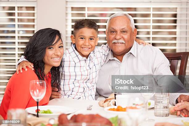 Family Posing With Grandfather For Holiday Photo Dinner Table Stock Photo - Download Image Now