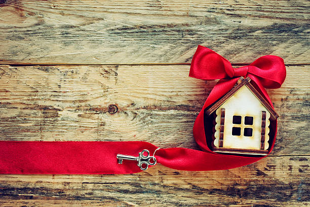 istock small house with red ribbon and key 518498792