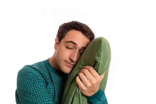 sleepyhead man in pajamas with its beloved pillow