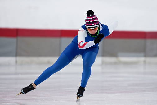 A woman doing a speed skating work out on a cold winter day.