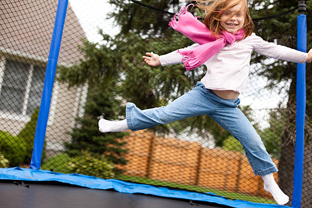 istock Happy Girl Jumping Outdoors on Trampoline 518501599