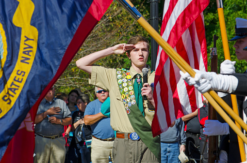 Belmont, North Carolina, USA - October 4, 2014: A Navy Color Guard of ROTC Cadets presents the American, Navy and Marine Corps Flags to North Carolina Governor, Pat McCrory during a speech dedicating a statue to honor the Veterans of World War II. An Eagle Scout leads the audience in the \