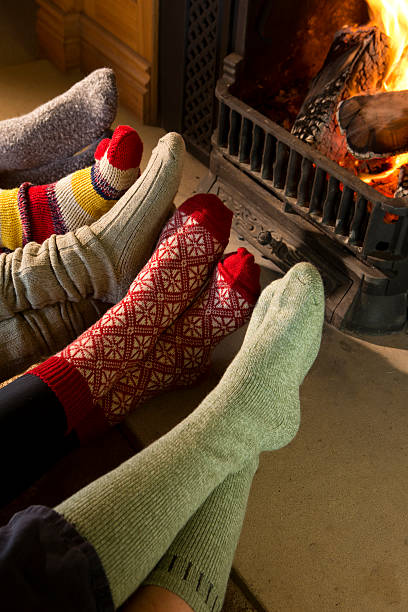 istock Five Pairs of Feet in Socks Warming by Fire 518504101