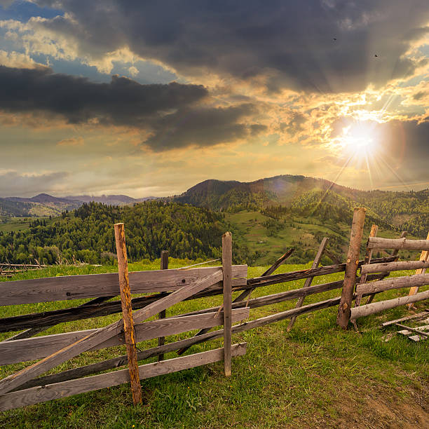 istock fence on hillside meadow in mountain at sunset 518504413