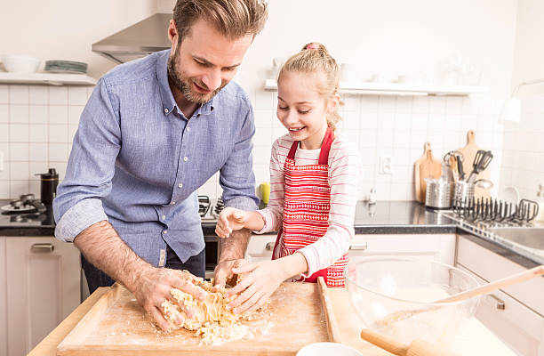 istock Happy father and daughter preparing cookie dough in the kitchen 518505492