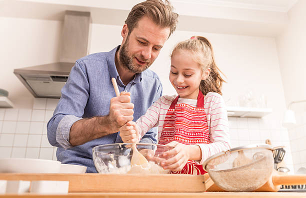 istock Father and daughter preparing cookie dough in the kitchen 518505874