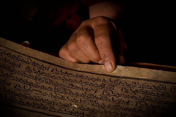 istock Hands of a Tibetan monk with an acient prayer book 518505930