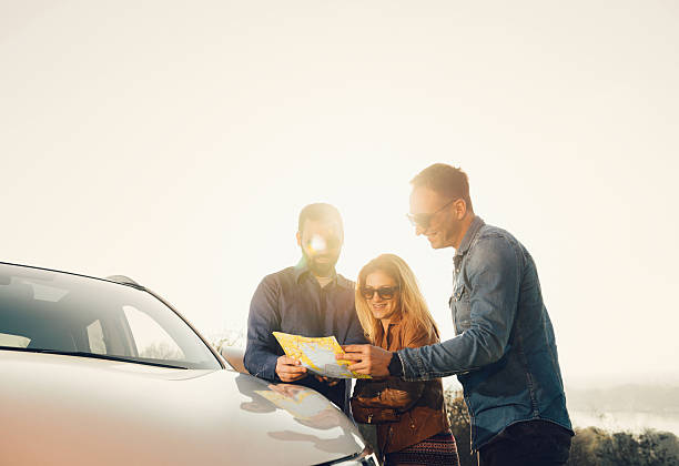 istock Group of people looking at map on springtime adventure trip 518507240