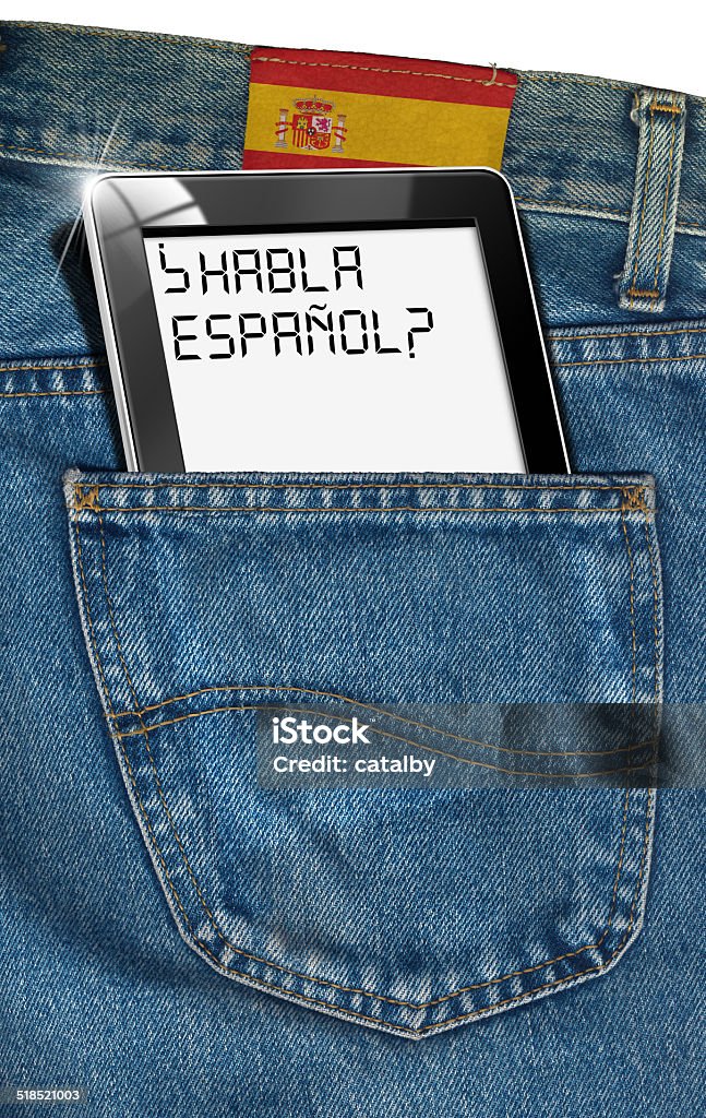 Tablet Computer - Spanish Everywhere Jeans with black tablet computer with phrase "Habla Espanol?" (do you speak Spanish?) in a pocket and label with flag of Spain - concept to speak Spanish everywhere Education Stock Photo