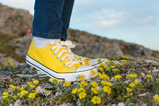 Woman on a hiking trip with close up at yellow sneakers