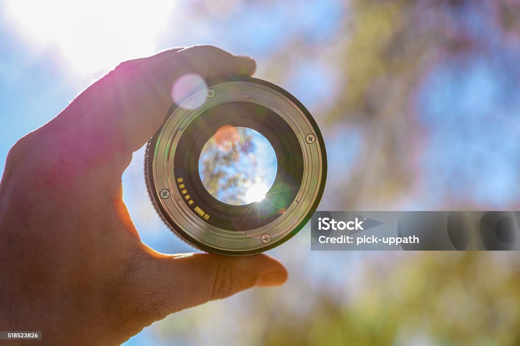 Photographer holding up lens Lens - Optical Instrument Stock Photo