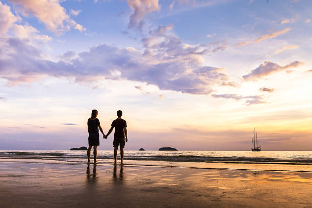 casal feliz tendo um passeio romântico, perto do mar - sunrise beach couple hiking - fotografias e filmes do acervo