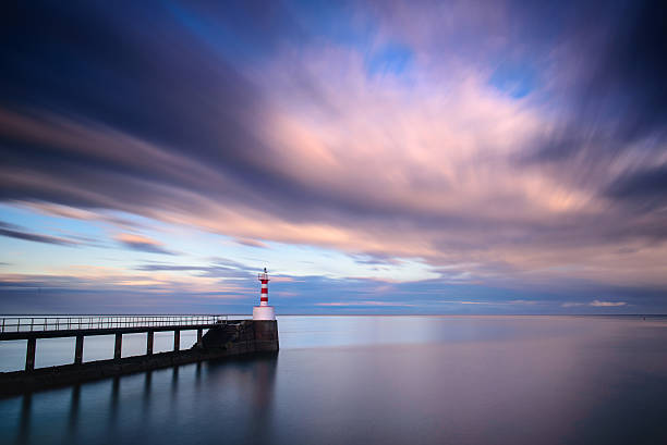 istock Amble pier and lighthouse at sunset long exposure 518524482