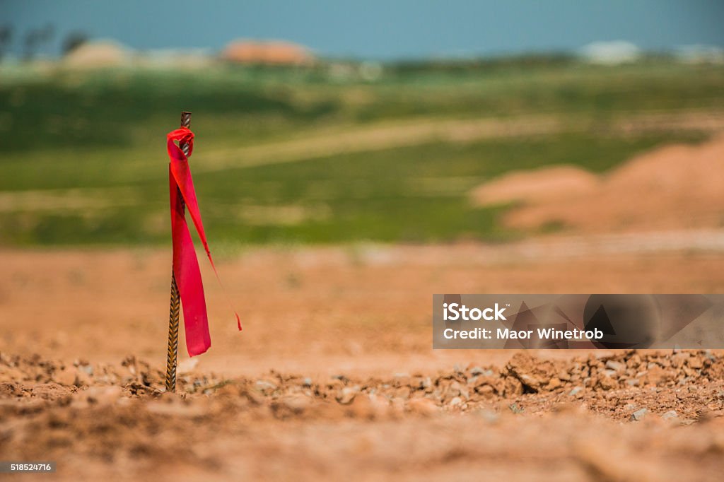 Metal survey peg with red flag on construction site Metal survey peg with red flag on construction site. Land Stock Photo