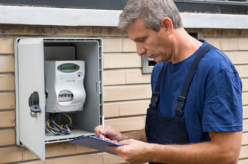 Portrait Of Electrician Worker Inspecting Electric Meter