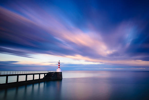 istock Amble pier and lighthouse at sunset long exposure 518524960