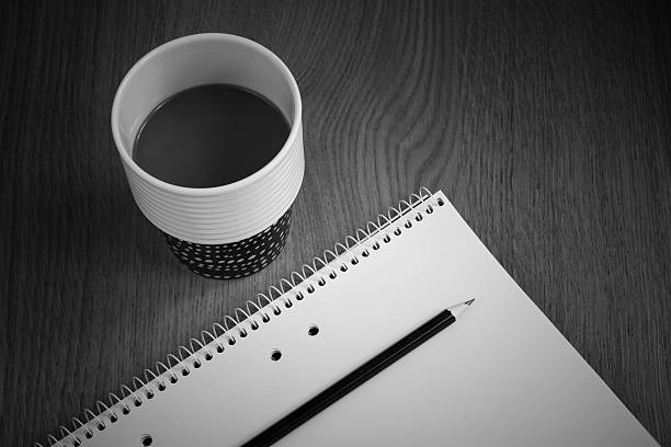 Cup of hot and notebook with pencil on white table background. Study time concept. selective focus.