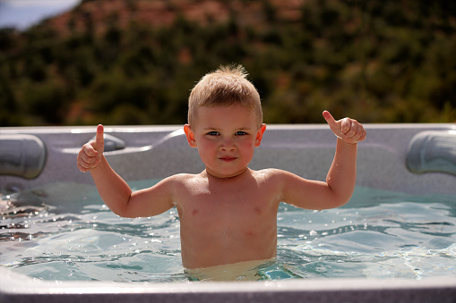 Picture of young boy holding lifebuoy at pool. High quality photo