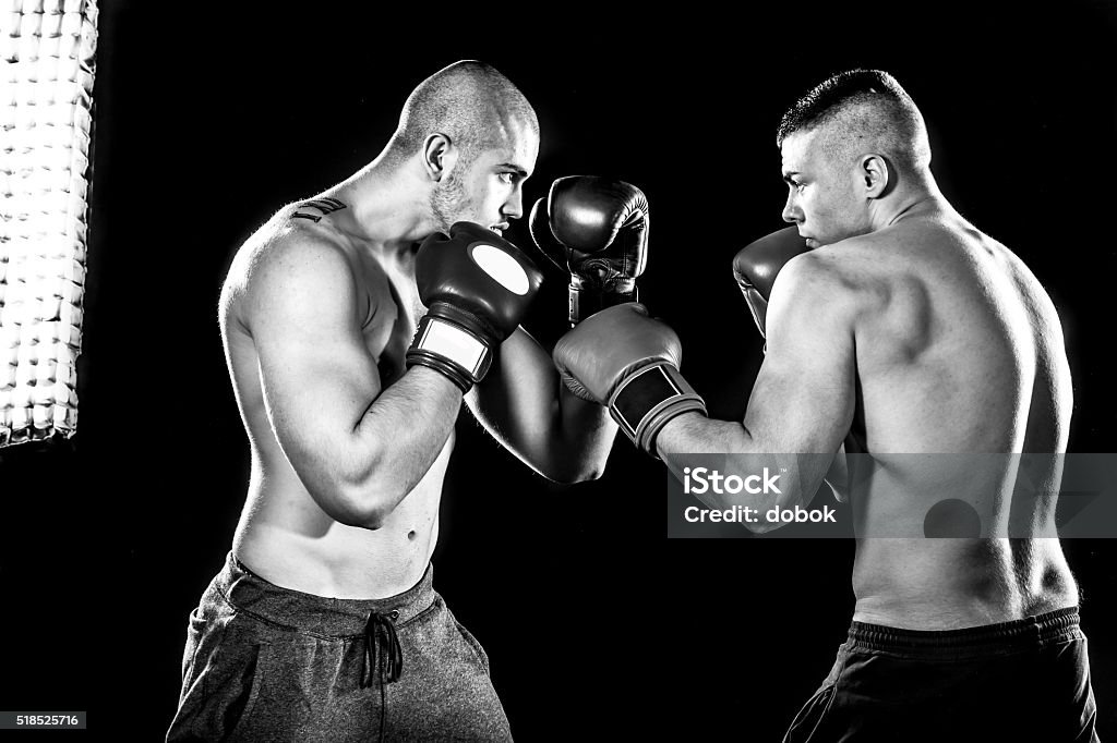 Boxers Two professional boxer isolated on black background, black and white photography, in studio low key with flash light Boxing - Sport Stock Photo